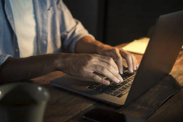 Freiberufler beim Tippen auf dem Laptop im Home Office - IKF01008