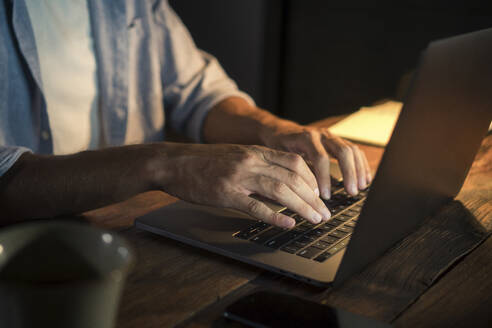 Freiberufler beim Tippen auf dem Laptop im Home Office - IKF01008