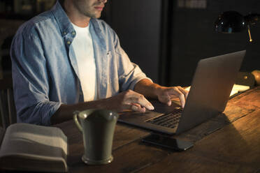 Freiberufler arbeitet am Laptop am Schreibtisch im Home Office - IKF01009