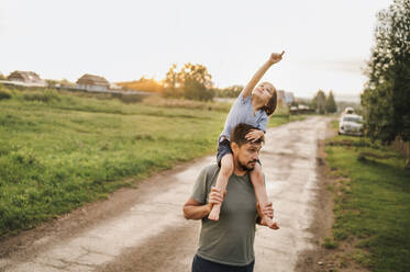 Father carrying son on shoulders at sunset - ANAF01876