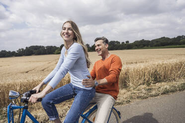 Glückliches Paar bei einer gemeinsamen Fahrradtour - UUF29695