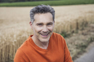 Smiling man in front of field - UUF29697