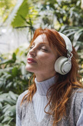 Frau hört Musik mit drahtlosen Kopfhörern - PNAF05895