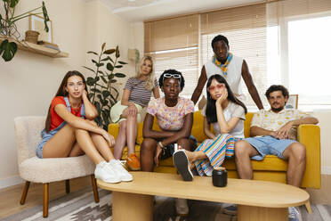 Multiethnische Freunde sitzen zu Hause auf dem Sofa - EBSF03716
