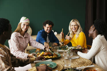 Happy friends having thanksgiving lunch at home - EBSF03722