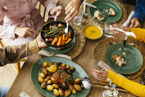 Friends having thanksgiving lunch at dining table - EBSF03724