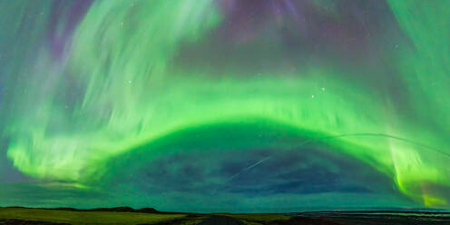 From below colorful green polar lights shining on sky over field with rocky formation in wild nature at night time in Iceland - ADSF46107