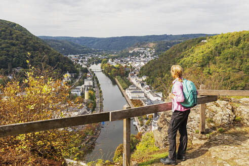 Deutschland, Rheinland-Pfalz, Bad Ems, Wanderin steht auf einer Anhöhe mit Blick auf die Kurstadt an der Lahn - GWF07894