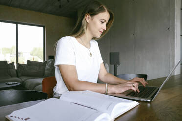 Freiberufler, der an einem Laptop im Büro zu Hause arbeitet - YHF00027