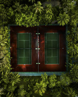 Aerial view of people playing tennis in a tennis courts of a luxury resort on the Himmafushi Atoll, Maldives. - AAEF19389