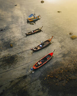Aerial view of few boats moored in mud at sunrise in Phuket, Thailand. - AAEF19443
