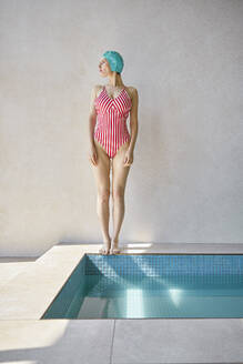 Contemplative woman standing barefoot by hot tub at spa - EKHF00037