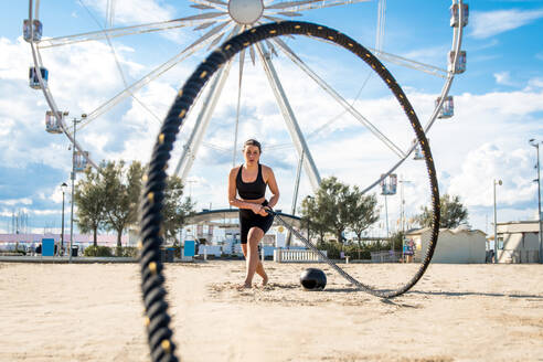 Funktionelles Training am Strand, fitte und sportliche Frau beim Sport im Freien - Konzepte zu Lifestyle, Sport und gesunder Lebensweise - DMDF00327