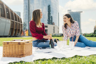 Glückliche Freunde beim Picknick vor einem Gebäude - MEUF09160