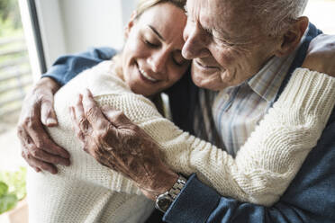 Smiling woman hugging father at home - UUF29935