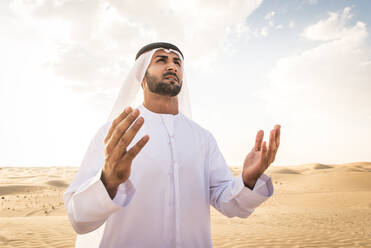 Arabische Männer mit Kandora beim Spaziergang in der Wüste - Porträt von zwei Erwachsenen aus dem Nahen Osten in traditioneller arabischer Kleidung - DMDF00400