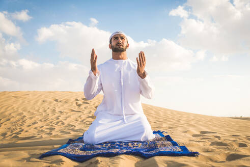 Arabische Männer mit Kandora beim Spaziergang in der Wüste - Porträt von zwei Erwachsenen aus dem Nahen Osten in traditioneller arabischer Kleidung - DMDF00407