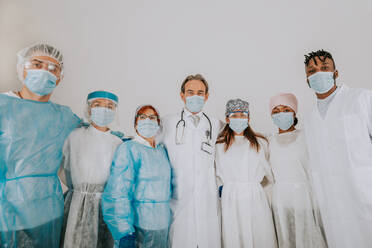 Team of doctors and nurses wearing disposable protection suits and face masks for fighting Covid-19 ( Corona virus ) - Medical team portrait during coronavirus pandemic quarantine, concepts about healthcare and medical - DMDF00475