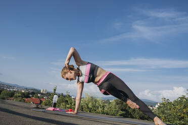 Reife Frau übt Yoga auf dem Dach - OSF01926