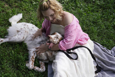 Young woman playing with dog in park - YBF00061