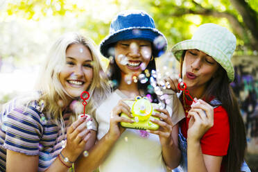 Smiling friends enjoying and spending time together in garden - EBSF03755