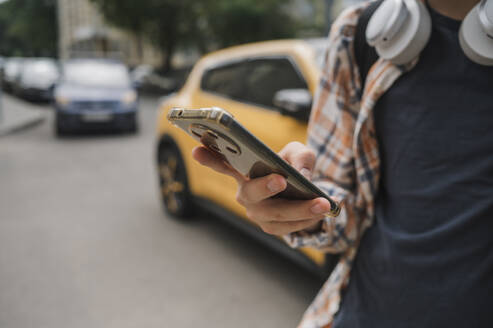 Teenage boy using smart phone on road - ANAF01901