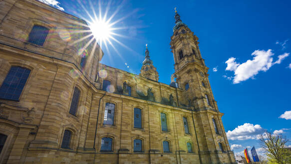Germany, Bavaria, Bad Staffelstein, Sun shining over Basilica of Fourteen Holy Helpers - MHF00723