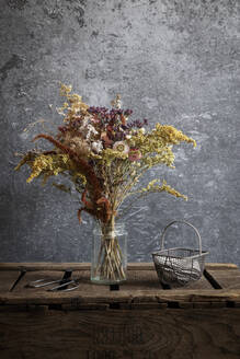 Arrangement of dried flowers in jar standing on wooden crate - EVGF04353