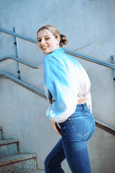 Lächelnde Frau, die eine Treppe hinaufgeht - YHF00042