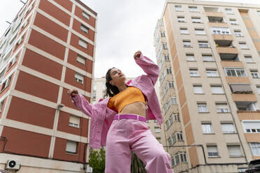 Modische Frau tanzt vor einem Gebäude - AFVF09286