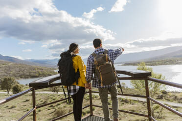 Man pointing by woman standing at observation point - JJF00969