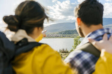 Woman gesturing towards mountains by man - JJF00970