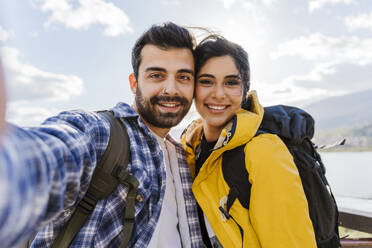 Smiling man taking selfie with woman on vacation - JJF00975