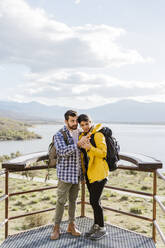 Tourist couple sharing smart phone standing at observation point - JJF00984