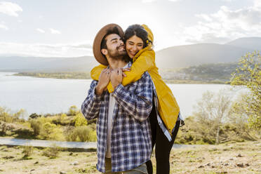 Smiling woman embracing man with eyes closed - JJF01018