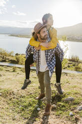 Boyfriend giving piggyback ride to girlfriend - JJF01019