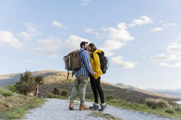 Romantic couple standing face to face on footpath - JJF01034