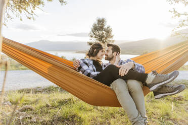 Smiling couple relaxing in hammock - JJF01053