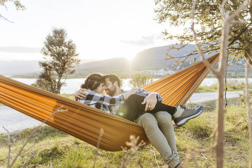 Romantic couple spending vacation sitting in hammock - JJF01055