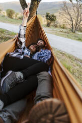 Girlfriend and boyfriend spending leisure time lying down in hammock - JJF01057