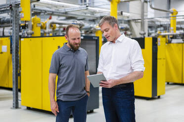 Employee and businessman with digital tablet talking in factory - DIGF20091