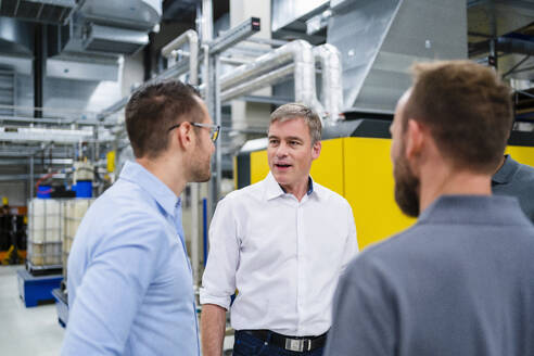 Businessman and employee having a meeting in factory - DIGF20114