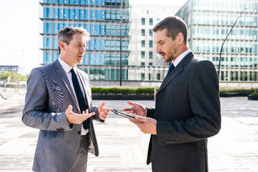 Multiracial group of business people bonding outdoors - International business corporate team wearing elegant suit meeting in a business park - DMDF00607