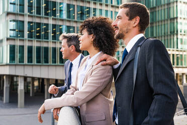 Multiracial group of business people bonding outdoors - International business corporate team wearing elegant suit meeting in a business park - DMDF00618