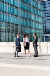 Multiracial group of business people bonding outdoors - International business corporate team wearing elegant suit meeting in a business park - DMDF00626