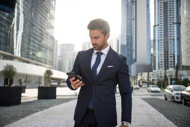 Handsome caucasian businessman - Portrait of a businessman walking outdoors - DMDF00668