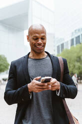 Young business man going to work in the morning passing by the financial street area of the city .Representation of a successful sales person reaching the top of the career. - DMDF00749