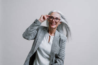 Schöne ältere Frau posiert auf einem Corporate Business-Foto-Session. Geschäftsfrau mit eleganten Anzug auf farbigen Hintergründen im Studio. - DMDF00786