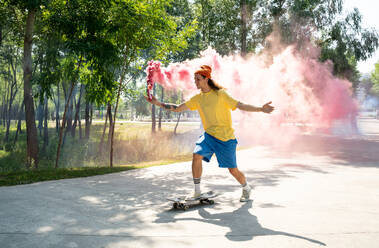 Skater mit farbigen Rauchbomben. Professionelle Skateboarder haben Spaß im Skatepark - DMDF00826