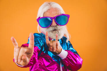Senior man with eccentric look - 60 years old man having fun, portrait on colored background, concepts about youthful senior people and lifestyle - DMDF00928